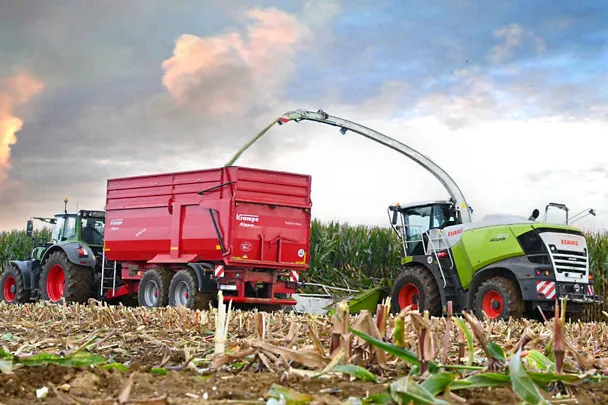 Traktor mit Ladewagen und Maishäcksler bei der Maisernte Traktor mit Ladewagen und Maishäcksler bei der Maisernte
