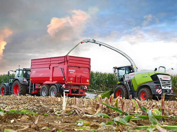 Traktor mit Ladewagen und Maishäcksler bei der Maisernte